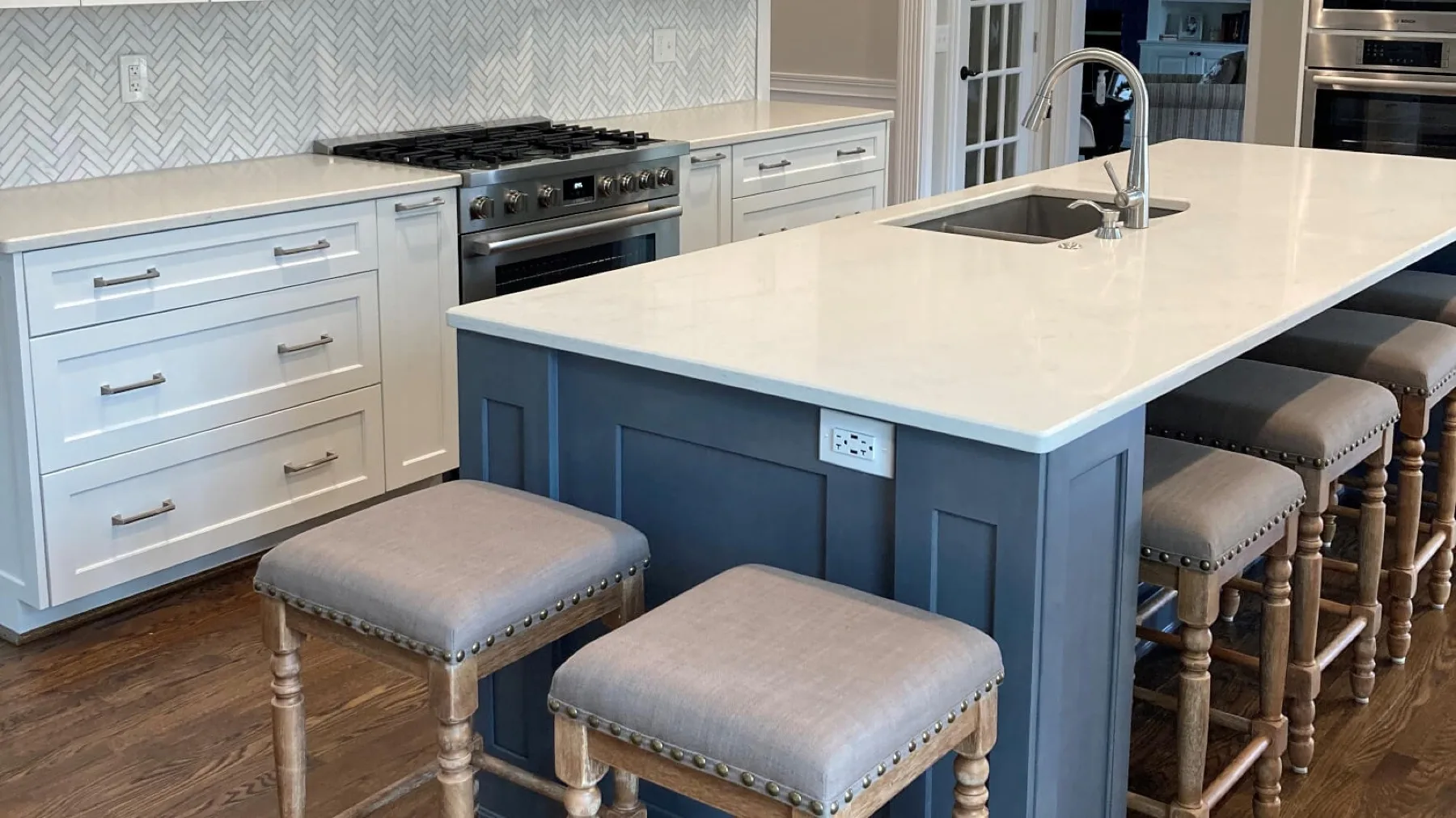 A remodeled kitchen island with a marble countertop by Keitz Construction