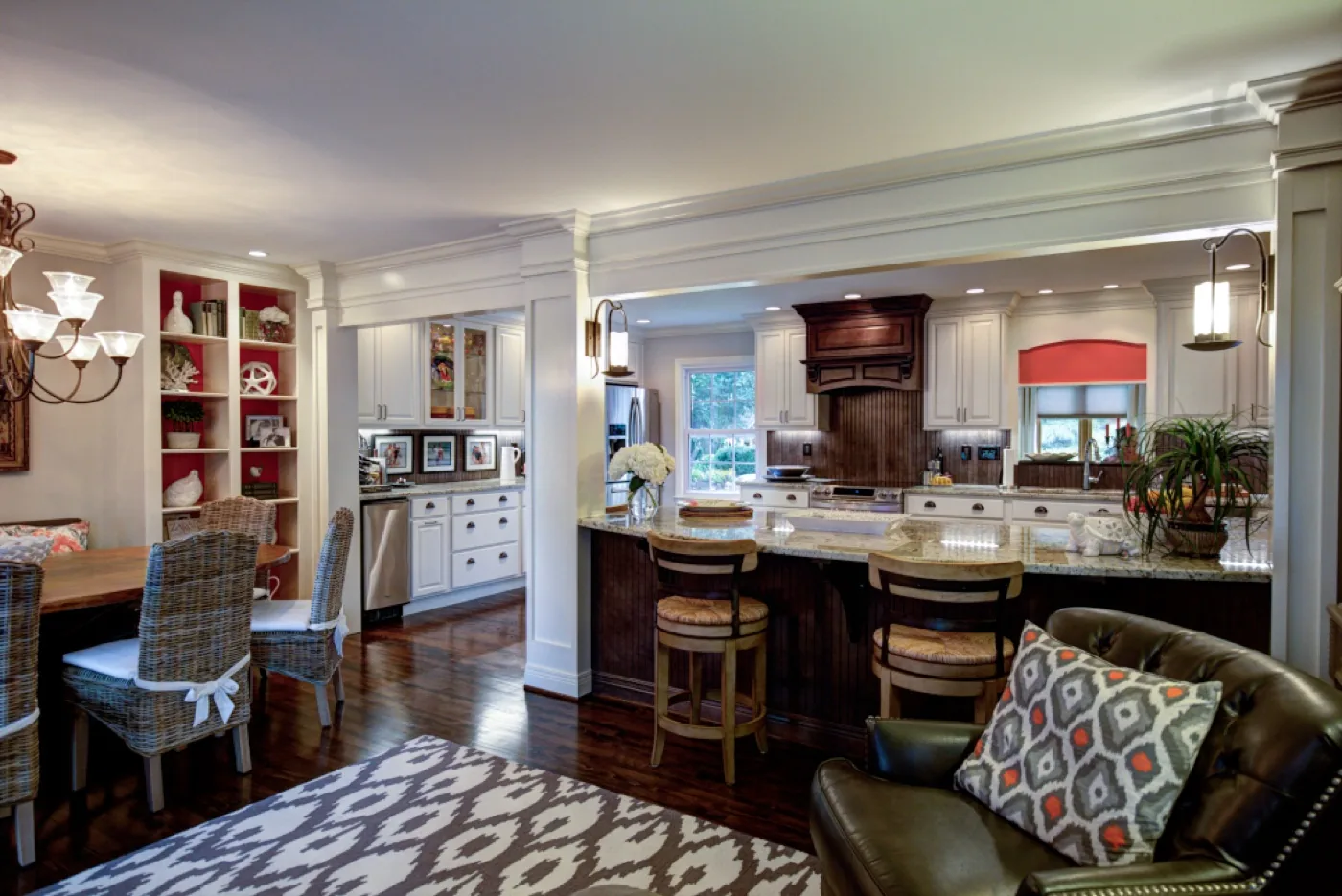 An open kitchen and dining room remodel by Keitz Construction with white cabinetry and a stained wood island