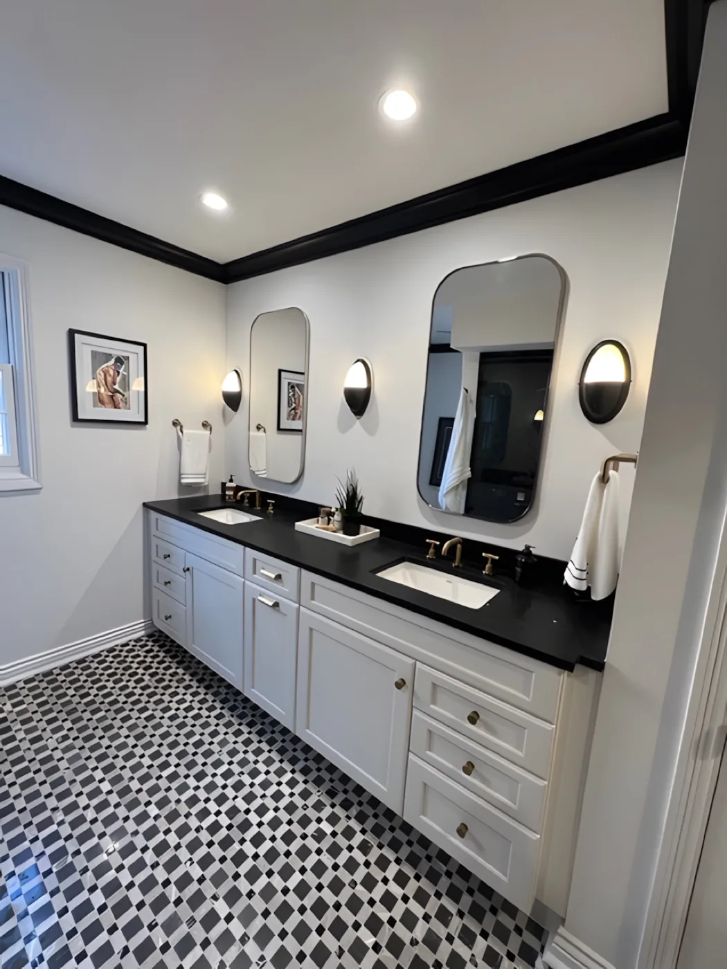 A remodeled bathroom with a black countertop, brass fittings and a patterned tile floor